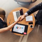 A business meeting shows a handshake signifying agreement in the vet sector.