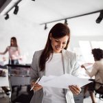 A businesswoman reviews training documents in an office, highlighting different assessment strategies.